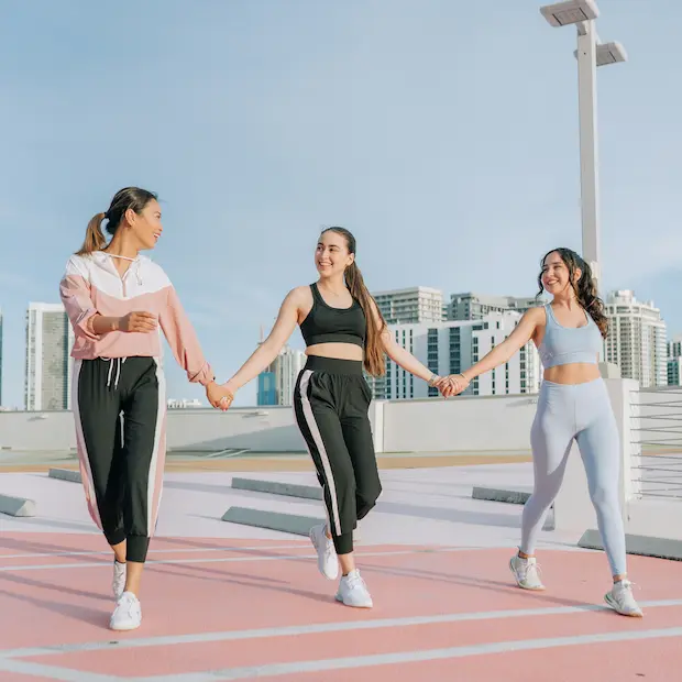 Trois adhérentes souriantes pendant le moment détente qui suit la sortie running
